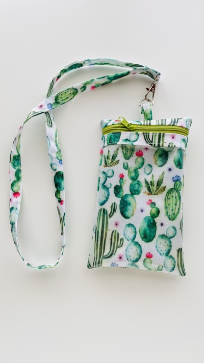Bolsa pequena com padrão de cactos verdes, flores e fecho amarelo com alça longa
