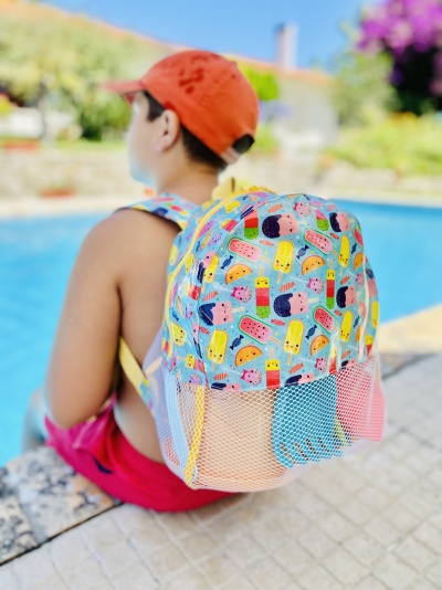 Mochila colorida com padrão de gelados ao lado de piscina