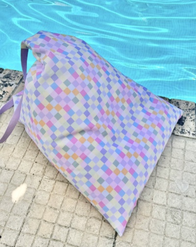 Almofada em tecido xadrez colorido junto à piscina