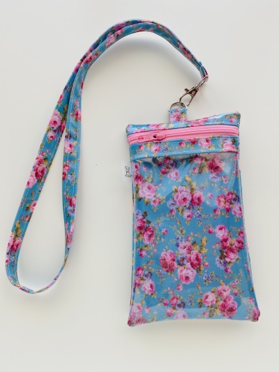 Bolsa pequena azul com padrão floral rosa e correia para pendurar