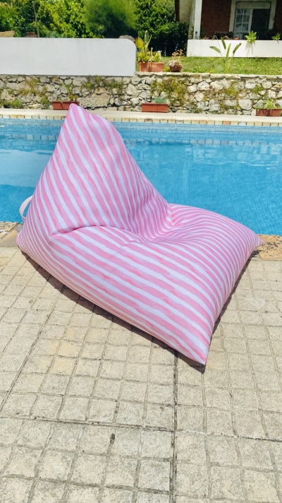 Puff rosa e branco junto a piscina