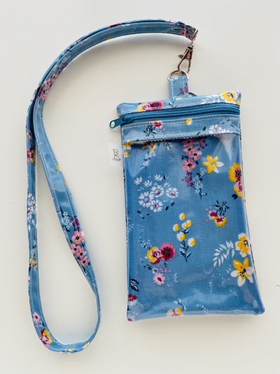 Bolsa azul pequena com padrão floral colorido e alça de pescoço