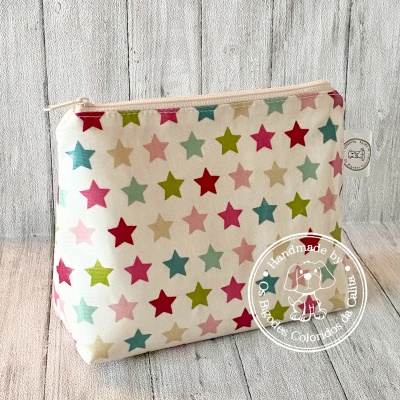 Bolsa de tecido com padrão de estrelas coloridas e fecho zipper