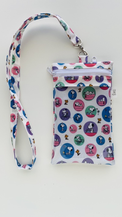 Necessaire com padrão Snoopy colorido e alça pendente