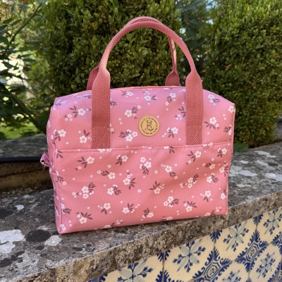 Bolsa rosa com flores pequenas e etiqueta redonda com cão
