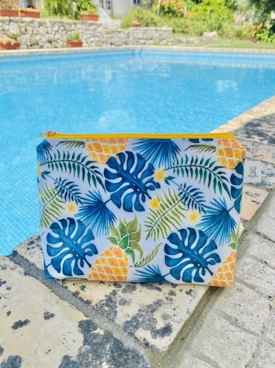 Estojo com padrão tropical azul e amarelo junto a piscina