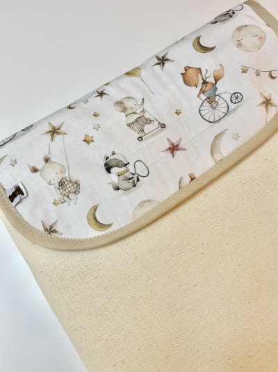 Bolsa de tecido bege com aba estampada com animais e estrelas
