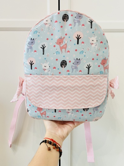 Mochila infantil azul clara com veados e bolso rosa com padrão ondulado branco