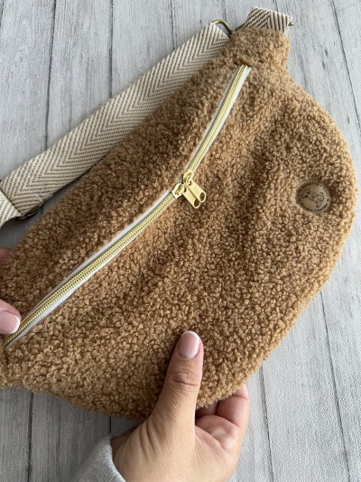 Bolsa castanha felpuda com fecho dourado e alça bege com padrão