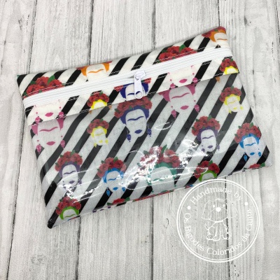 Necessaire retangular com padrão listrado preto e branco e faces femininas coloridas com flores