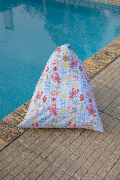 Pufe triangular colorido junto a uma piscina