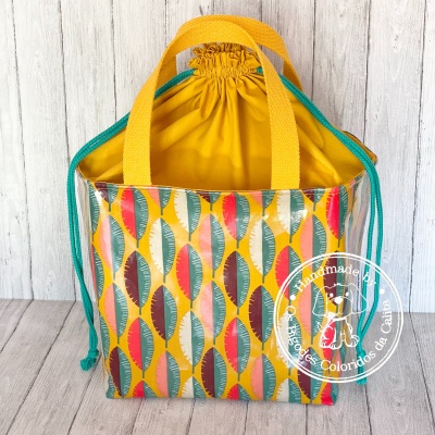 Bolsa colorida com padrão de folhas e alças amarelas