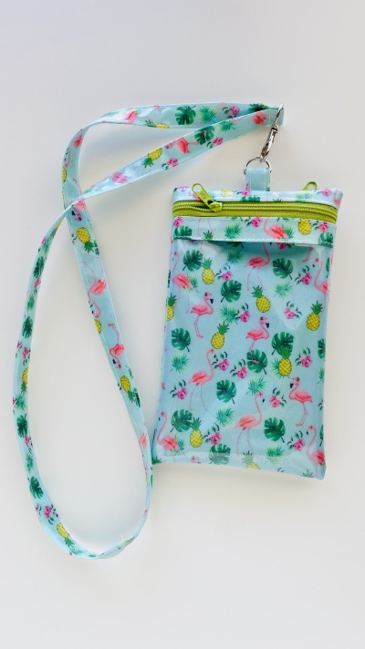 Bolsa azul com padrão colorido de flamingos, ananases e folhas com fecho zip e alça comprida