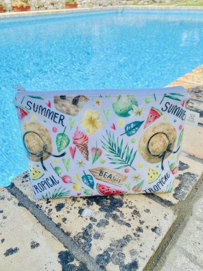 Necessaire branca com padrão tropical colorido junto à piscina
