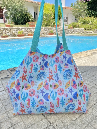Saco de tecido com padrão marinho colorido junto a piscina