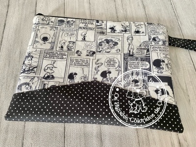 Bolsa de tecido com desenhos de banda desenhada e padrão de bolinhas brancas sobre fundo preto