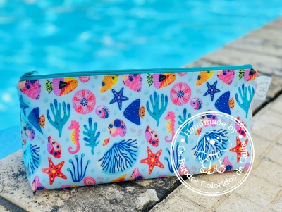 Estojo colorido com padrões marinhos num parapeito junto a piscina