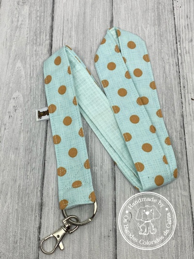 Lanyard azul claro com bolinhas castanhas e mosquetão metálico