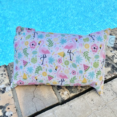 Almofada estampada com flamingos e frutas junto à piscina