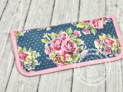 Estojo têxtil floral azul com rosas cor-de-rosa e amarelas e bordas cor-de-rosa