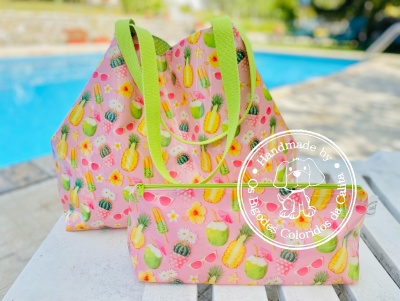 Conjunto de bolsa rosa com padrão de frutas tropicais e flores e carteira, alças verdes, selo branco, ao ar livre junto a piscina
