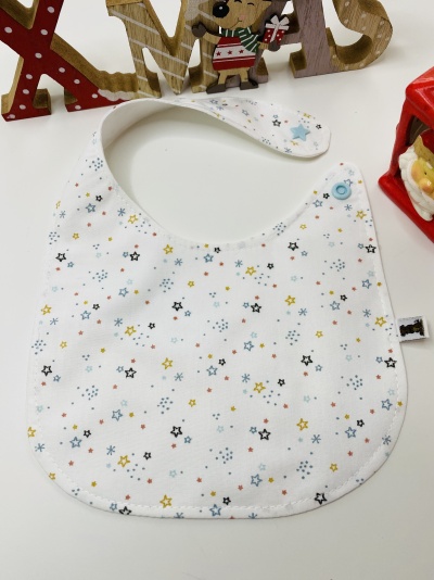 Babete branco para bebé com padrão de estrelas coloridas e fecho azul