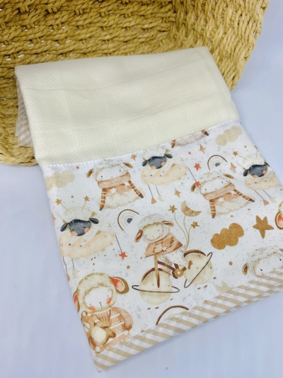 Toalha de bebé branca e bege com padrão de cordeiros e estrelas