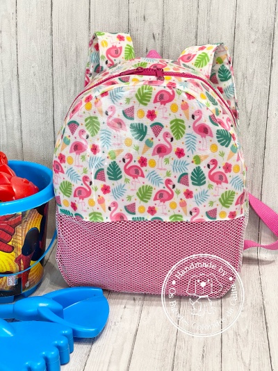 Mochila infantil com estampa colorida de flamingos e flores e balde azul com brinquedos