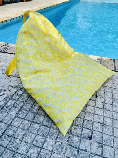 Cadeira amarela de tecido com padrão de limões junto à piscina