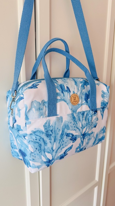 Mala de tecido azul e branco com padrão aquarelado e alças azuis