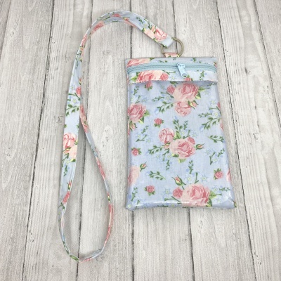 Bolsa fina azul claro com padrão floral rosa e alça comprida