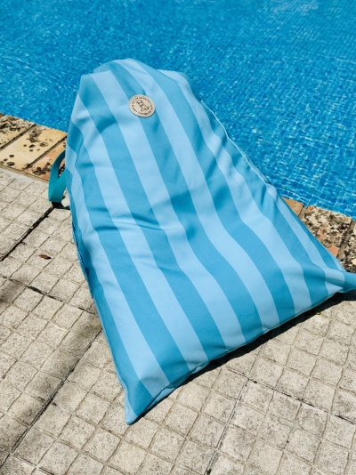 Pufe triangular riscado azul junto a piscina