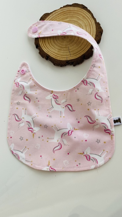 Babete rosa com padrão de unicórnios e fecho de pressão
