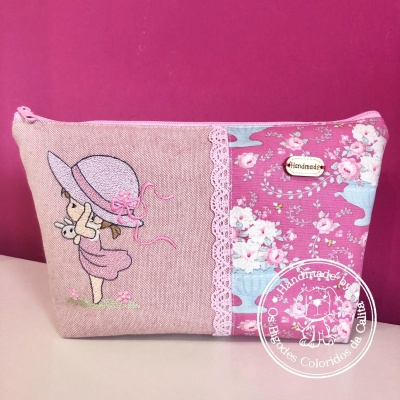 Necessaire rosa com bordado de menina, padrão floral e etiqueta handmade