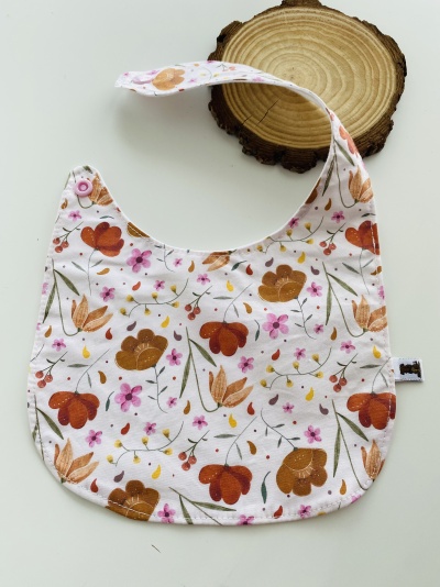 Babete de tecido com padrão floral em tons de laranja e rosa
