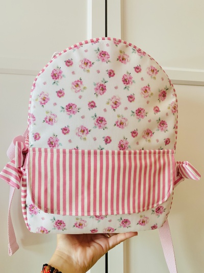 Mochila branca com padrão floral rosa e bolso riscado rosa e branco