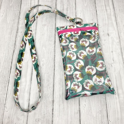 Bolsa pequena transparente com padrão floral e fecho rosa, alça longa estampada