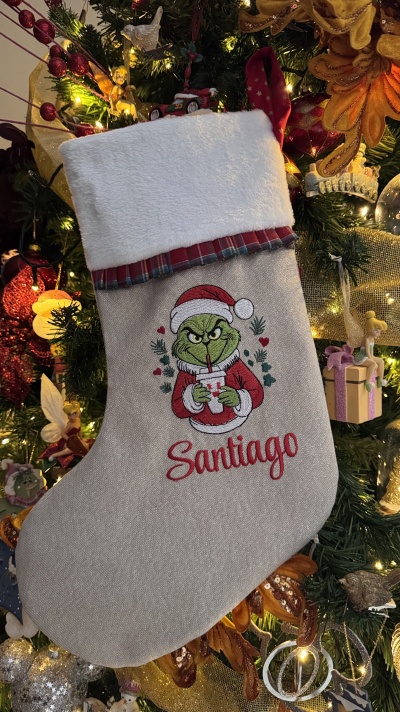 Meia de Natal personalizada com o Grinch e nome Santiago pendurada numa árvore decorada