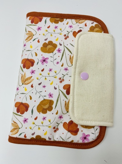 Capa floral com bordas castanhas e fecho lilás