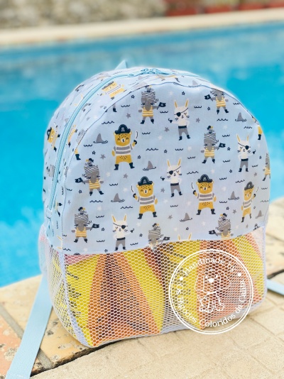 Mochila infantil azul clara com padrão de ursos e coelhos em roupas de pirata junto a uma piscina