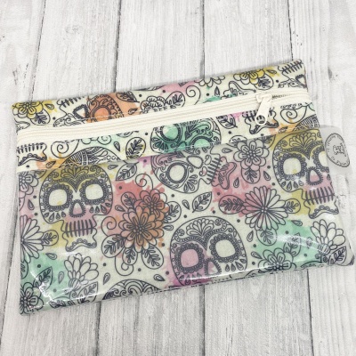 Estojo colorido com padrão de caveiras e flores e fecho branco