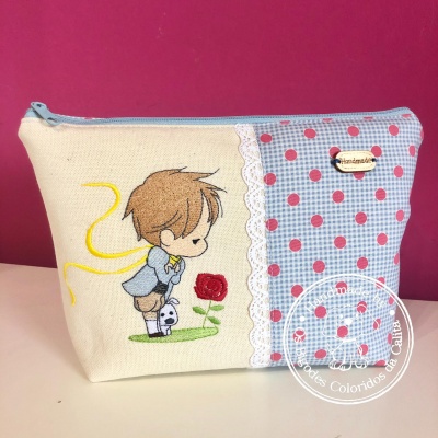 Necessaire bege e azul com bordado de criança, rosa e mini boneco, com fecho de correr azul.