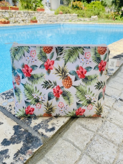 Estojo com padrão tropical de ananases, flores e folhas, junto à piscina