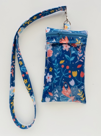 Carteira pequena azul escura com padrão floral colorido e fita para pendurar.