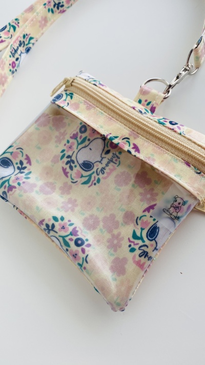 Carteira pequena em padrão floral pastel com desenho de Snoopy e alça com mosquetão