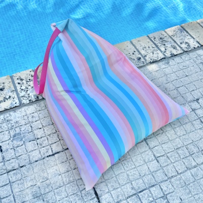 Almofada listrada colorida ao lado de piscina