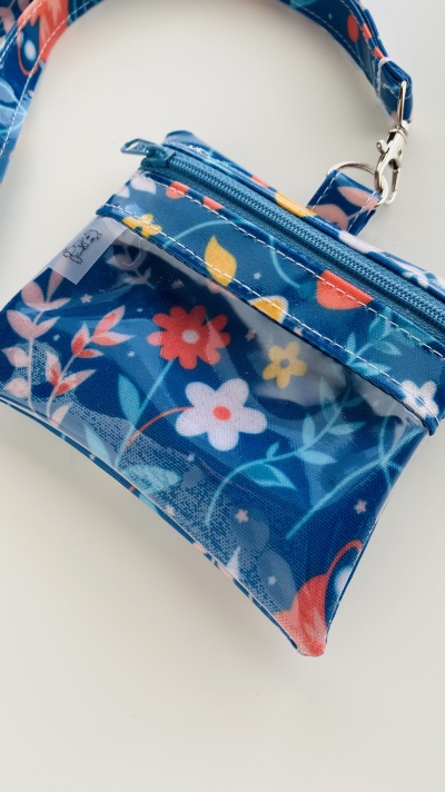 Bolsa pequena azul com padrão floral e fecho de correr