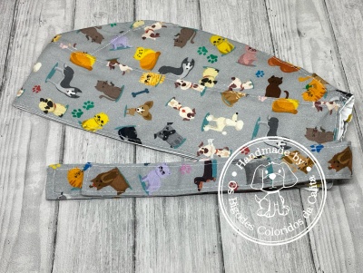 Touca e faixa com padrão de cães coloridos sobre fundo cinza