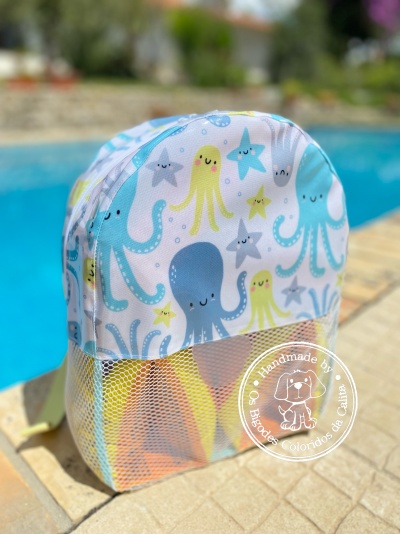 Mochila infantil com padrão de polvos junto a piscina