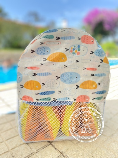 Mochila infantil com padrão de peixes coloridos e bolso em rede branca